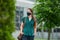 A young woman in a medical face mask walks keeping social distance in downtown