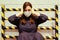 A young woman in a medical mask covered her ears against a black-and-yellow barrier. Siren and sound warning of problems