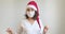 Young woman in medical mask and Santa Claus hat dancing and having fun. Close up of female in Christmas hat and