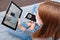 A young woman in a medical mask sits at home in quarantine and calls an online doctor for advice on the symptoms of coronavirus