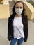 Young woman in medical mask on street. Adult female protecting yourself from diseases. Concept of threat of coronavirus