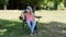 Young woman in a medical protective mask and sunglasses with funny rabit ears hat sits in a chair and uses a fan to cool. Covid-19