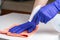 Young woman in medical purple gloves disinfecting the table surface with sanitizing antibacterial wipes. Protection against COVID-