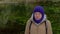 Young woman meditates on a background of green lake