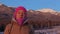 Young woman meditates at the foot of the mountains.