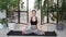 Young woman meditating indoors. Woman sitting in the lotus position. Relaxation and meditation at home near the plants