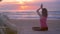 Young Woman meditating in lotus position on wooden walkway at sea shore