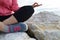 young woman meditation in a yoga pose at the beach. girl in lotus position on an empty stone seashore. takes yoga, sports,