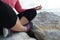 young woman meditation in a yoga pose at the beach. girl in lotus position on an empty stone seashore. takes yoga, sports,