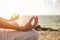 Young woman meditation yoga pose on tropical beach with sunlight