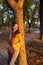 Young woman millennial enjoying a autumn sunset at city park