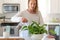 Young woman misting a houseplant