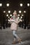 A young woman in mittens and a hat on a winter night under the lights