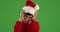 Young woman modeling Santa Claus hat, smiling and laughing on green screen