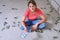 Young woman with money sitting on the floor in an empty apartment. The cost of repairing a new home. Financial investments in real