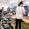 Young Woman Or Mother With Baby In Pushchair Or Stroller Paying For Food At Automated Till
