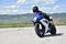 Young woman motorcyclist speeding on tarmac racetrack