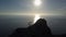 Young woman in mountains waving her hand. Lady reaching the summit in beautiful scenery over sea.