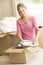 Young Woman Moving Into New Home Unpacking Boxes