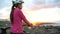 Young woman MTB cyclist wearing bike helmet resting looking at sunset view