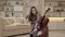 Young woman musician with long hair tuning cello sitting at home