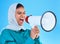 Young woman, muslim and loudspeaker in studio for protest, human rights and scream by blue background. Girl, islam and