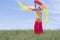 A young woman in a national costume is dancing an oriental dance in the lap of nature