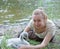 The young woman near a baby bird of a swan on the bank of the lake