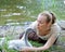 The young woman near a baby bird of a swan on the bank of the lake