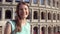 Young woman near famous attraction Colosseum in Rome, Italy. Female tourist smiling in slow motion