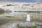 Young woman  near a lake with light water and sandy hills. Beautifull vew on natural landscape with thunderstorm clouds. Freedom