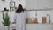 Young woman in nightie prepares breakfast in the kitchen in the morning