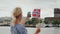 A young woman with a Norwegian flag photographes herself against the background of the Oslo city line. Travel