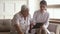 Young woman nurse caregiver holding clipboard consulting old elder man