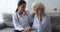 Young woman nurse doctor supporting comforting depressed old grandma patient