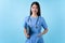 Young woman in nurse uniform smile isolated on light blue background