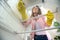 Young woman observed from the inside of a refrigerator doing some shelf cleaning