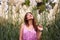 Young woman observing some wildflowers above her and surround in background