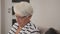 Young woman offers tea to an elderly lady while she is reading a book