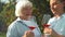 Young woman and old senior woman with glass of wine in vineyard on sunny day. A group of girlfriends raise a toast with
