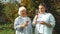 Young woman and old senior woman with glass of wine in vineyard on sunny day. A group of girlfriends raise a toast with