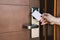 Young woman opening hotel room electronic lock with key card