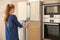 Young woman opening refrigerator doors