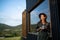 Young woman outdoors, weekend away in container house in countryside.