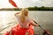 Young Woman Paddling Kayak on the Beautiful River or Lake at Sunset. Back View from the Second Place in Boat.