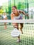 Young woman padel tennis player trains on the outdoor court