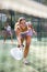 Young woman padel tennis player trains on the outdoor court