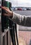 A young woman with painted nails and a nice sweater, manipulates some buttons of a gas pump in a service station