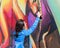 A young woman paints a picture with a color spray on a concrete security fence on the border between Israel and Lebanon.