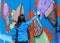 A young woman paints a picture with a color spray on a concrete security fence on the border between Israel and Lebanon.